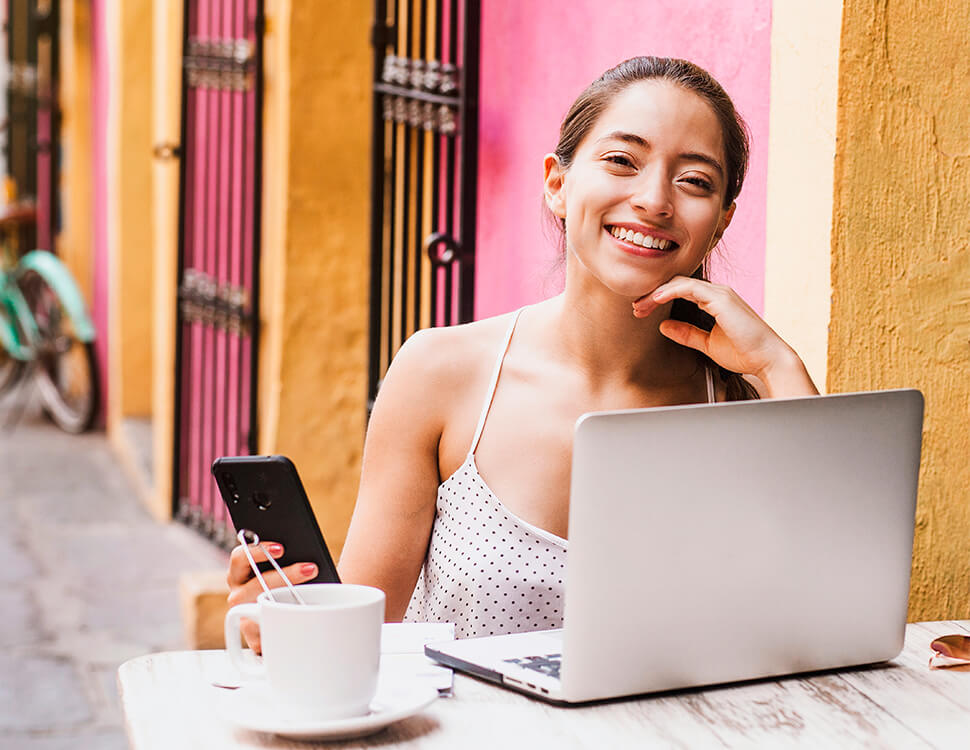 Mulher que segura um smartphone e sorri