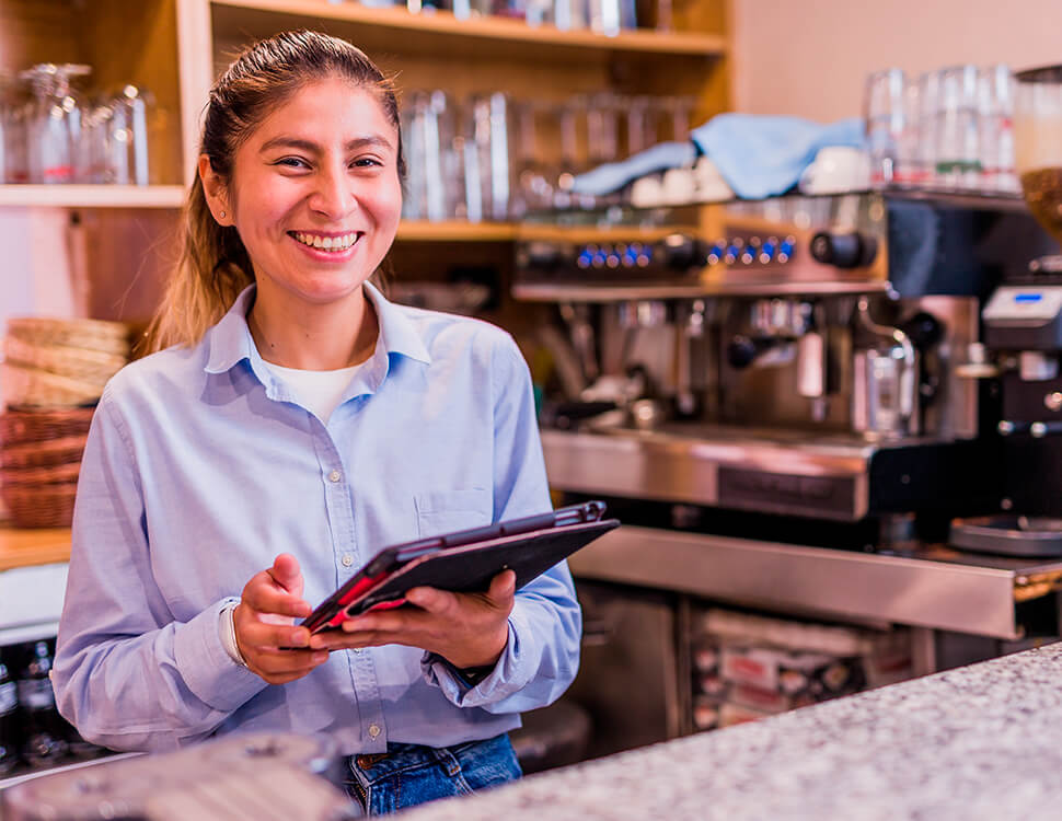 Mulher que está sorrindo enquanto segura um tablet